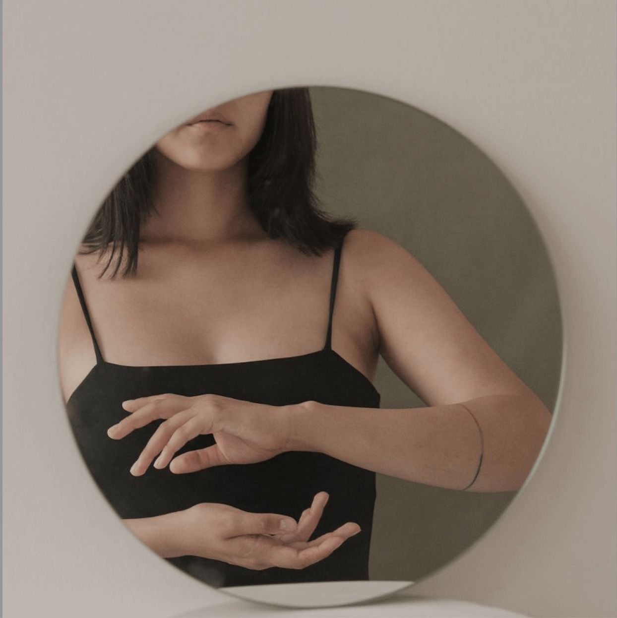 woman in reflection with hands in circle