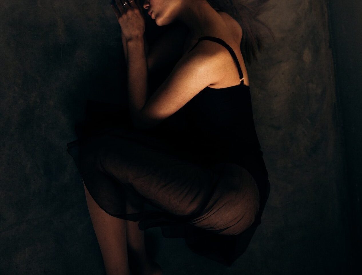 woman laying dark in dark hues